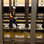A worker surveys the flooded Lincoln Center subway station, in New York, . A water main break flooded streets on Manhattan's Upper West Side near Lincoln Center and hampered subway service during the Monday morning rush hour
